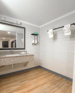 a bathroom with a large mirror and a sink at Gateway Inn in Graham