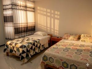 a bedroom with two beds and a window at Casa Alojamiento Virreynal in San Ramón