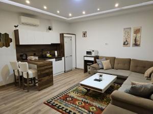 a living room with a couch and a table and a kitchen at Apartment Music in Sarajevo