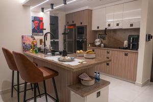 a kitchen with a island with bar stools at Copper Living in Muscat