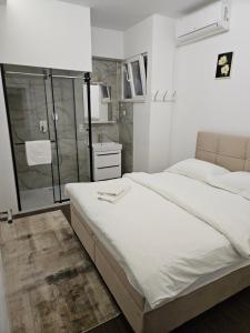 a bedroom with a large bed and a shower at Apartment Music in Sarajevo