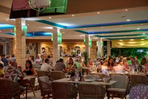 a group of people sitting at tables in a restaurant at LA CARETTA S1 in Alikanas