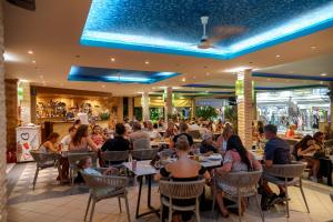 a group of people sitting at tables in a restaurant at LA CARETTA S1 in Alikanas