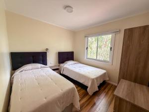 a bedroom with two beds and a window at Arriendo casa Caburgua Pucón in Caburgua