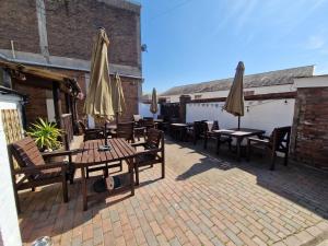 a patio with tables and umbrellas on a building at The Swan Hotel in Lydney