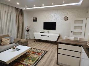a living room with a couch and a tv at Apartment Music in Sarajevo