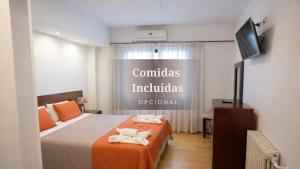 a hotel room with a bed and a flat screen tv at Gran Hotel Miglierina in Mar del Plata