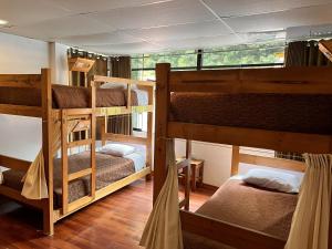 a room with three bunk beds in a house at Nativus Hostel Machu Picchu in Machu Picchu