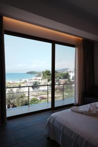 a bedroom with a large window with a view of the ocean at Hotel Lula Ksamil in Ksamil +193 photos