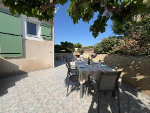 a table and chairs sitting on a patio at Escales du Sud, Frontignan Plage in Frontignan