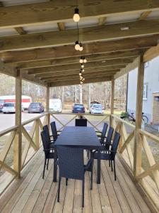 a black table and chairs on a wooden deck at Nordic Calm Forest Apartment in Hävla