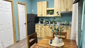 a kitchen with a wooden table and a black refrigerator at Churros Apartahotel in La Libertad