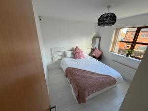 a bedroom with a bed with pink pillows and a window at Relax In Belfast in Belfast