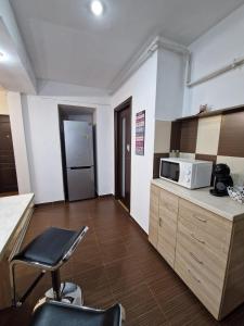 a kitchen with a microwave on a counter and a chair at Dixi Studio in Timişoara