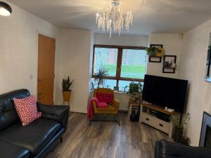 a living room with a couch and a flat screen tv at Relax In Belfast in Belfast