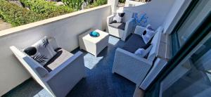 a balcony with chairs and a table on a building at CAPERCIA home in Forio d'Ischia