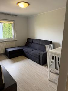 a living room with a couch and a table at Mała Tyczkówka in Stężyca