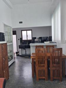 a kitchen with a wooden table and chairs at Villa Amber Breeze in Mirissa