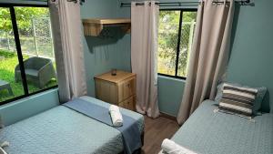 a bedroom with two beds and two windows at Churros Apartahotel in La Libertad +39 photos