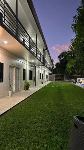 a house with a large yard of green grass at Churros Apartahotel in La Libertad
