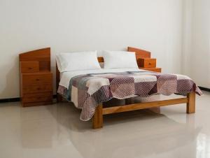 a bedroom with a bed and a dresser with a bedskirtspectspectspects at Casa Alojamiento Virreynal in San Ramón +20 photos