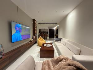 a living room with a couch and a flat screen tv at Copper Living in Muscat