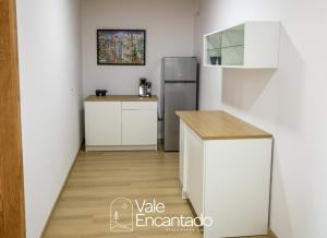 a kitchen with white cabinets and a refrigerator at Vale Encantado in Parada de Ester