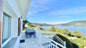 a balcony with a table and a view of a lake at The Cliffs - ArealongaBeach in O Vicedo +63 photos