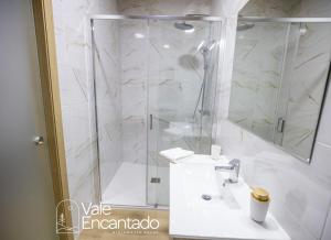 a white bathroom with a shower and a sink at Vale Encantado in Parada de Ester +19 photos