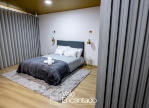 a bedroom with a bed with a blue blanket and white pillows at Vale Encantado in Parada de Ester