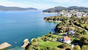 an aerial view of a house on a island in the water at The Cliffs - ArealongaBeach in O Vicedo