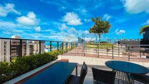 a balcony with tables and chairs and a blue sky at Move Tambaú Genius Flats in João Pessoa