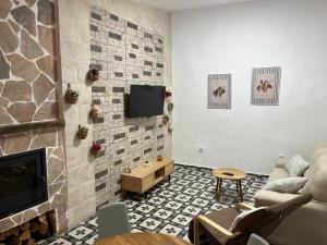 a living room with a fireplace and a tv at La casa de Inocen in Cilleruelo
