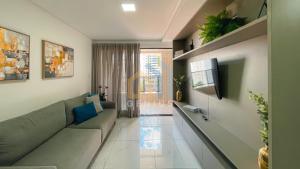 a living room with a couch and a tv at Move Tambaú Genius Flats in João Pessoa