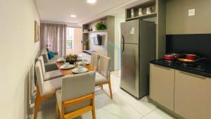 a kitchen and dining room with a table and a refrigerator at Move Tambaú Genius Flats in João Pessoa