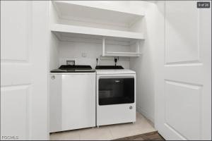 a white kitchen with a stove and white cabinets at Casa Lux in Florida City +13 photos