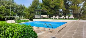 a swimming pool with chairs and a gazebo at Casa Rural MONTE VERDE in Illana