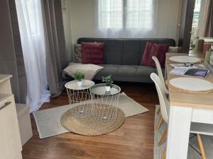 a living room with two tables and a couch at Camping le petit RIO in Noyelles-sur-Mer