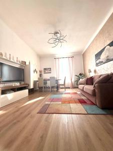a living room with a couch and a television at Benaco Apartment - 98mq Comfort & Style -Milano- Fondazione Prada in Milan