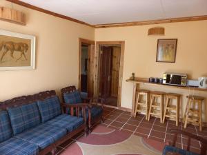 a living room with blue couches and a bar at Pecan Cottage Three in Machadodorp