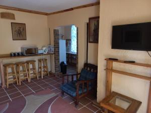 a living room with a fireplace and a tv at Pecan Cottage Three in Machadodorp