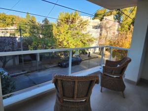 a balcony with two chairs and a view of a car at Piero House in Villa Mercedes