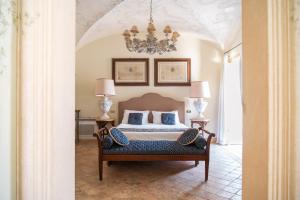 a bedroom with a bed and a chandelier at Palazzo Nobili in Capri