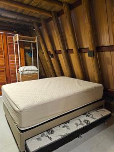 a large bed in a room with wooden walls at Cabana Redonda Beach in Icapuí