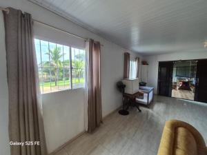 a living room with a large window and a chair at Bom sossego in Foz do Iguaçu