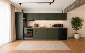 a kitchen with green cabinets and a sink at Arena Park in Bucharest