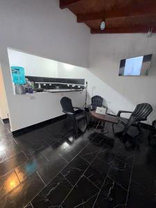 a room with two chairs and a table and a counter at Esquina Hostel in Esquina