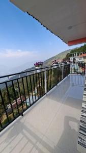 a balcony with a view of the ocean at Chamling Retreat in Kalimpong