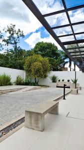 a bench sitting on a sidewalk in a park at Patios de City Bell Hotel and Apartments in City Bell