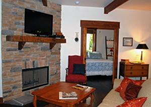 a living room with a brick fireplace with a tv at Timber Ridge in Franklin